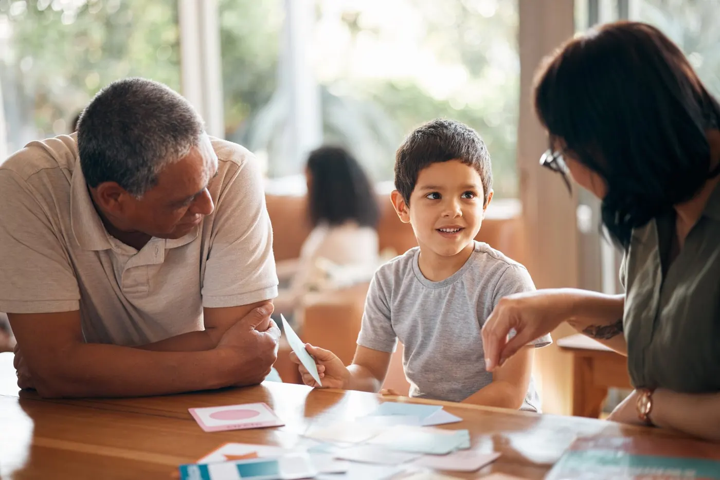 Pai, mãe e filho à mesa numa sessão com a psicóloga