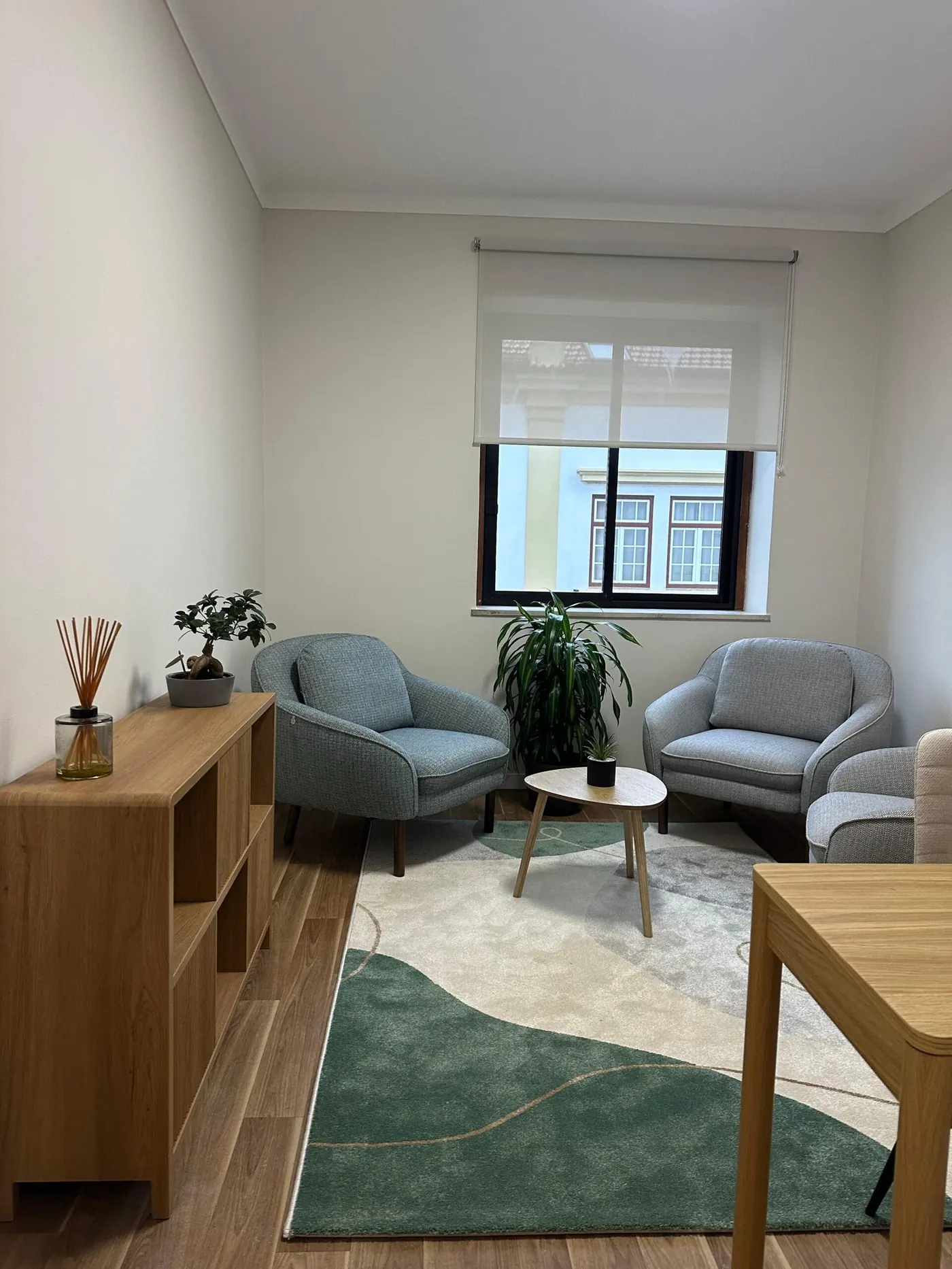 Sala de consulta vista da porta, com janela e cortina de rolo